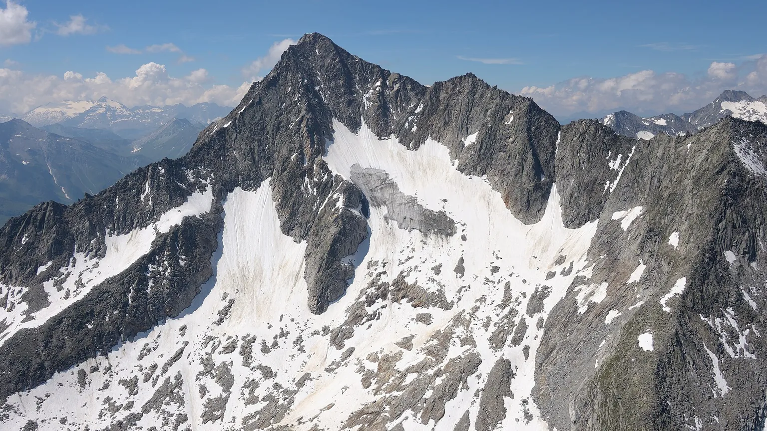 Groene bergweiden en een authentiek Tiroler bergdorp met besneeuwde Alpentoppen